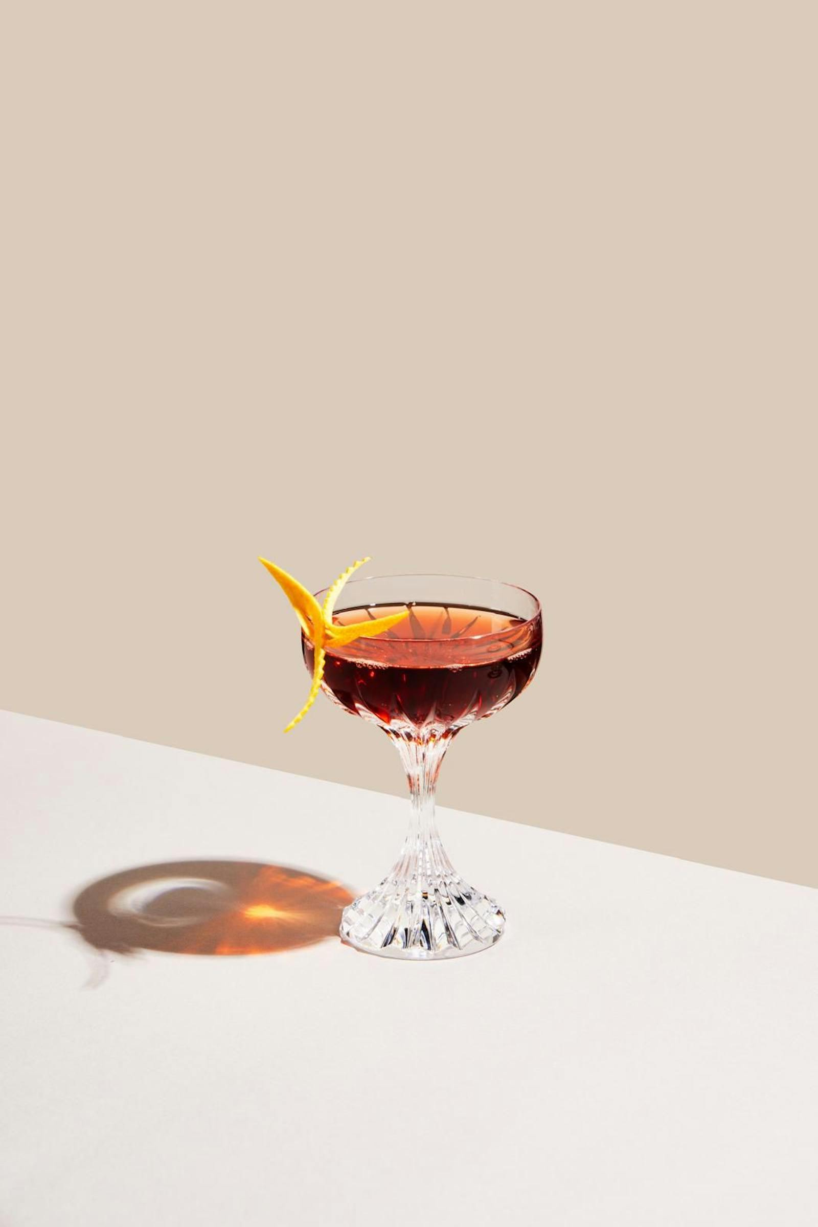 A dark spirit-forward coupe with orange-peel garnish